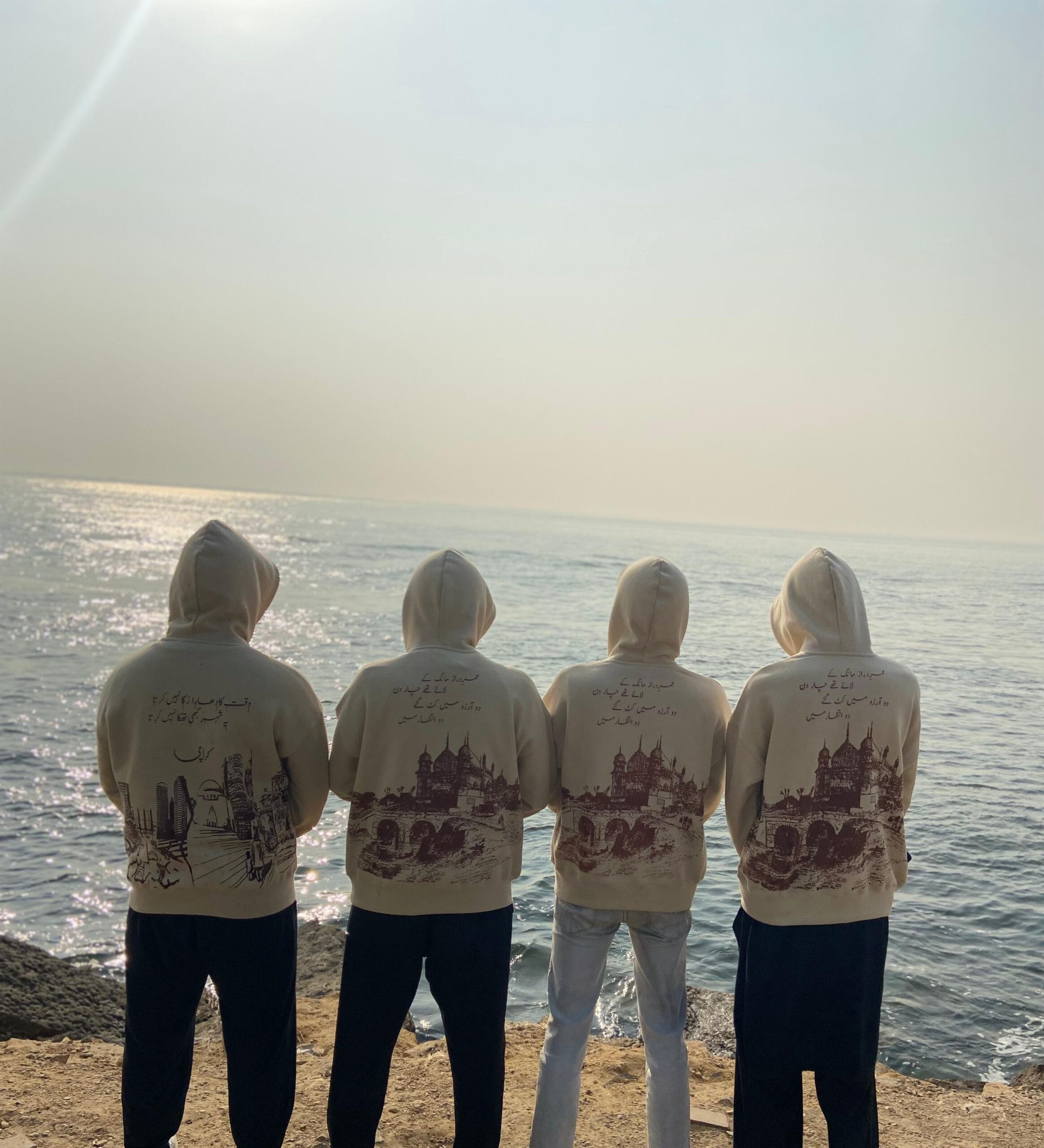Four people facing the ocean.